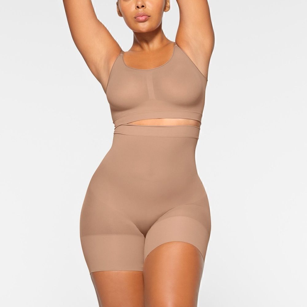SKIMS high-waisted mid thigh short in color sienna in the size Small